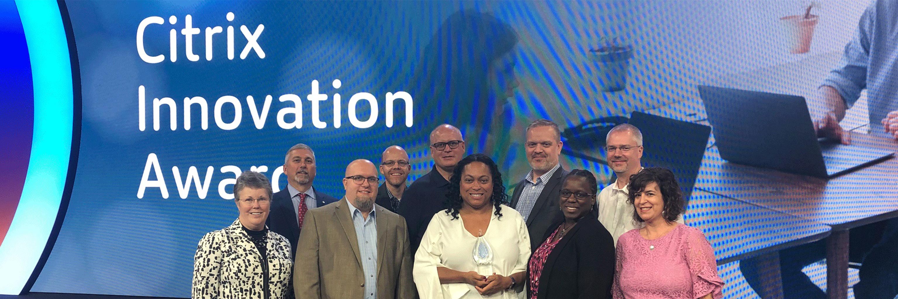 Group of people in front of large Citrix background video screen